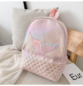 Detail showing mermaid tail embroidery and iridescent scale texture on a pink backpack
