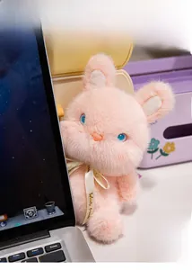 Detail of pink plush rabbit toy with blue eyes and Woody Friends ribbon on neck