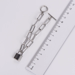 Flat cross chain bracelet with heart lock measured on a scale, silver metal design