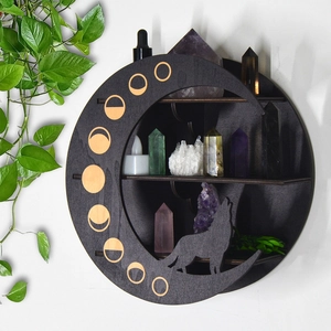 Detail of bohemian black wooden moon wolf crystal display shelf with candles and stones