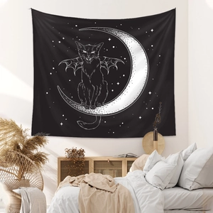 Detail of bohemian bedroom wall art featuring a black moon and cat tapestry hanging