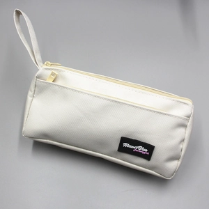 Detail view of double-zippered canvas pencil case with Almost Blue woven label