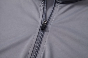 Close-up of the grey zipper and synthetic fabric texture on a long sleeve sun shirt