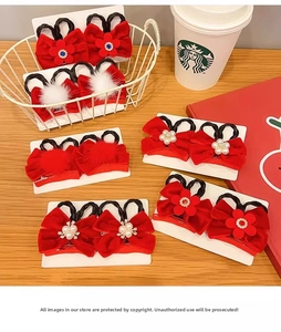 Detail of red festive bow hair clips with pearls and plush balls for girls