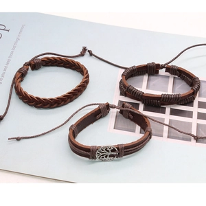 Detail shot of three brown leather woven bracelets set on a magazine background