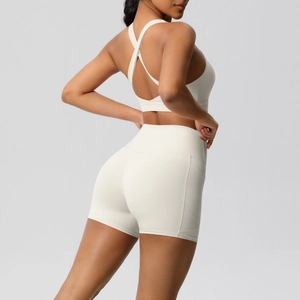 Detail of cross-back yoga bra and high-waisted fitness shorts with side pockets