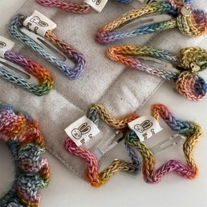 Close-up of rainbow knit hair clips and scrunchies set with rabbit cotton labels