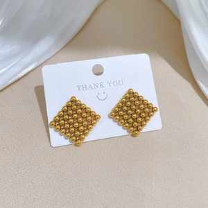 Detailed close-up of golden square grid stud earrings made of tiny titanium steel beads