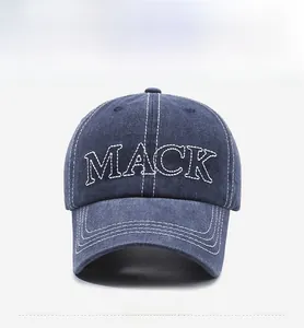Dettaglio del ricamo MACK e cuciture a contrasto su cappellino in denim blu scuro