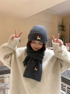 Detailed embroidery of Lucky Piggy dog pattern on dark grey knitted hat and scarf set