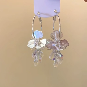 Détail des boucles d'oreilles fleurs avec pendentifs en cristal sur carte