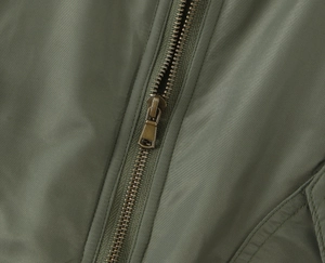 Close-up of retro copper zipper on army green military jacket twill fabric