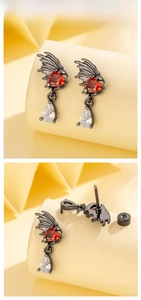 Detailed view of gothic angel wing earrings with red heart stone and black metal finish