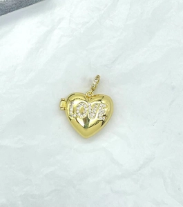 Macro view of a gold heart locket pendant with sparkling LOVE rhinestone lettering detail