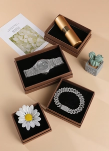 Close-up of luxury iced-out watch and Cuban link bracelet set in a brown velvet gift box