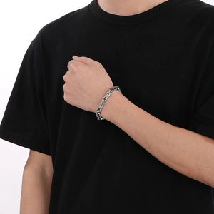 Gros plan d'un bracelet argenté épais pour hommes avec maillons rectangulaires de style industriel