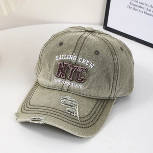 Macro detail of distressed olive green canvas baseball cap with NYC embroidery