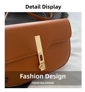 Detail of caramel brown leather saddle bag featuring a sleek gold metal bar buckle closure