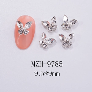 Macro detail of silver butterfly nail charms with 9.5x9mm dimensions on pink fake nails