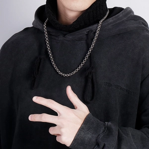Vintage stainless steel dragon bone chain necklace for men worn over a black hoodie