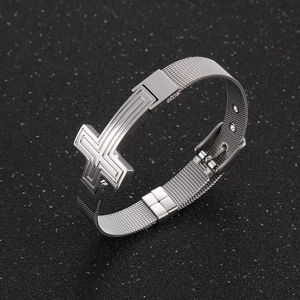 Detail of silver cross charm on adjustable metal mesh band with buckle closure