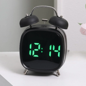 Detalle del reloj digital LED retro con campanas y pantalla verde de la hora 12:14