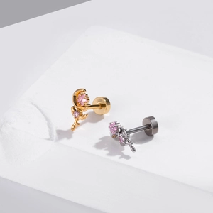 Detail of moon and flower piercing studs with pink zircon in gold and silver finish