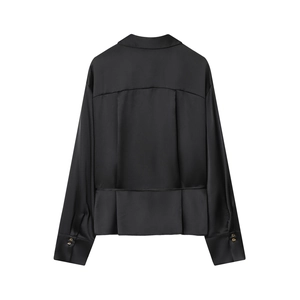 Dettaglio della camicia di raso nero sul retro con trama setosa e bottoni d'oro