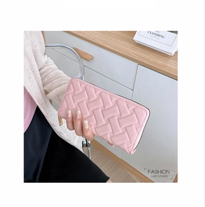Detail of pink woven leather long wallet with golden zipper held in hand for lifestyle use