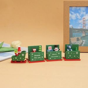 Detail of green wooden Christmas train with Santa, snowman and gift icons on beige background