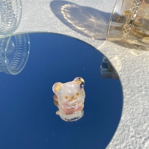 Gros plan d'une mini pince à cheveux en acétate rose avec détails dorés sur un miroir