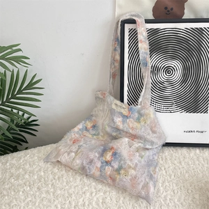 Detailed macro shot of lace tote bag featuring colorful 3D flower clusters and fabric texture