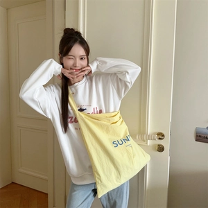 Close-up of bright yellow canvas tote bag with blue Sun and Summer printed letters