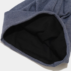 Détail de la texture en maille gaufrée bleu-gris foncé et de la doublure chaude en polaire noire