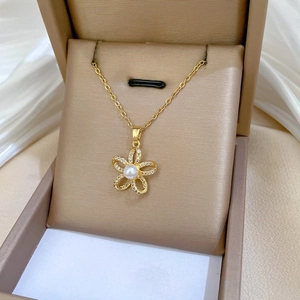 Detail of five-petal flower necklace with pearl center in a luxury jewelry box