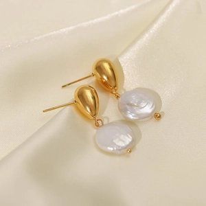 Elegant gold teardrop freshwater pearl drop earrings for women on beige silk background