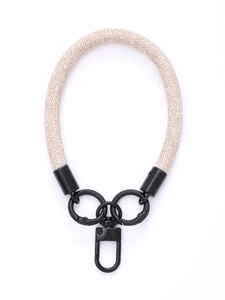 Detailed view of beige braided wrist strap with black metal clips for mobile phone cases