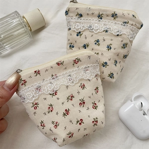 Floral makeup pouch detail featuring red and blue patterns with delicate lace trim