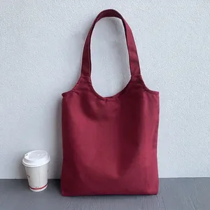 Detail shot of the wine red canvas tote bag showing thick fabric texture and sturdy straps