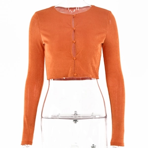 Détail du cardigan court orange avec fermeture boutonnée et manches longues