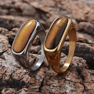 Macro detail of retro tiger eye stone rings on natural bark showing textures