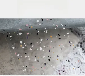 Macro detail of terrazzo style nail stickers with colorful geometric stone patterns