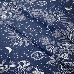 Detail of bohemian mandala tapestry featuring moon, stars and daisy patterns on navy fabric