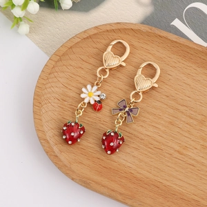 Detail of red strawberry keychains with rhinestones and golden heart-shaped clips
