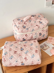 Detail of pink quilted makeup bag set with cute cartoon prints and bubble texture finish