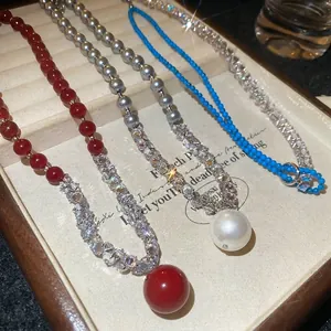 Elegant beaded necklaces with pearls and zircon stone pendants in white jewelry tray
