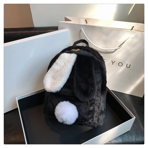 Detail of cute lamb wool bunny backpack in black and white inside a premium gift box