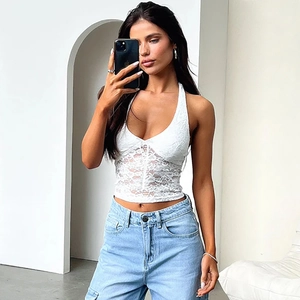Mirror selfie showing a white lace halter top paired with light blue high-waist jeans