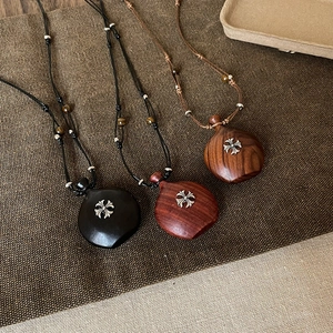Vue détaillée de colliers en bois faits main avec incrustation de croix et perles
