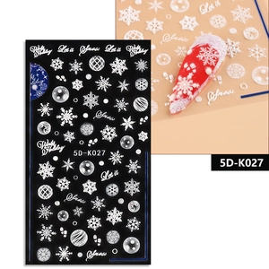 Macro detail of 5D white embossed Christmas nail decals with snowflake and holiday patterns